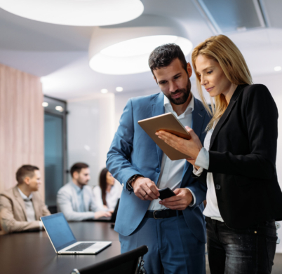 Businesspeople discussing while using digital tablet in office together